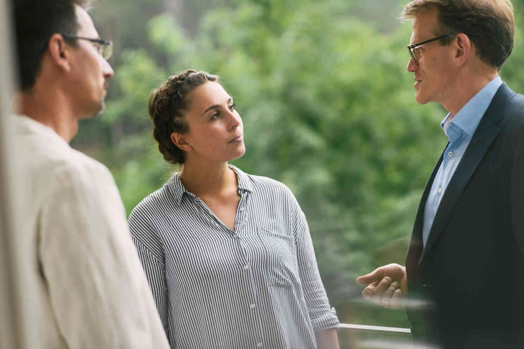 Eine gruppe von menschen steht drau&szlig;en und unterh&auml;lt sich